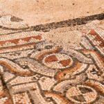 Ancient mosaic depicting a pale-coloured cat named Emerald resting on a cushion